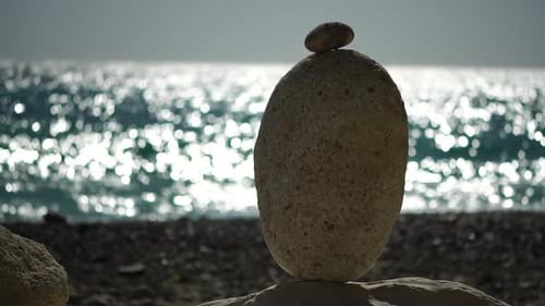 Balanced Pebbles Pyramid on the Beach on Sunny Day and Clear Sky at Sunset Golden Sea Bokeh on