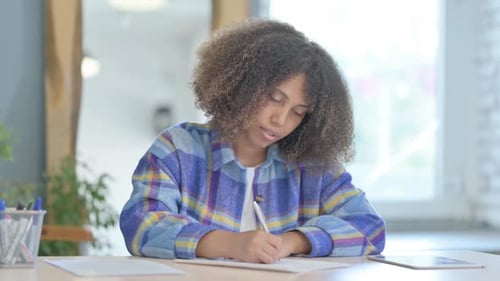 Young Adult Writing at Desk Indoors