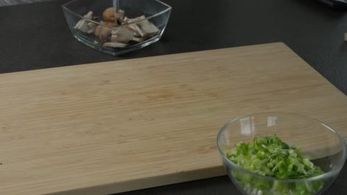 Slicing Fresh Mushrooms on Cutting Board in Kitchen