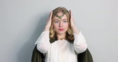 Beautiful elf girl posing on light grey background