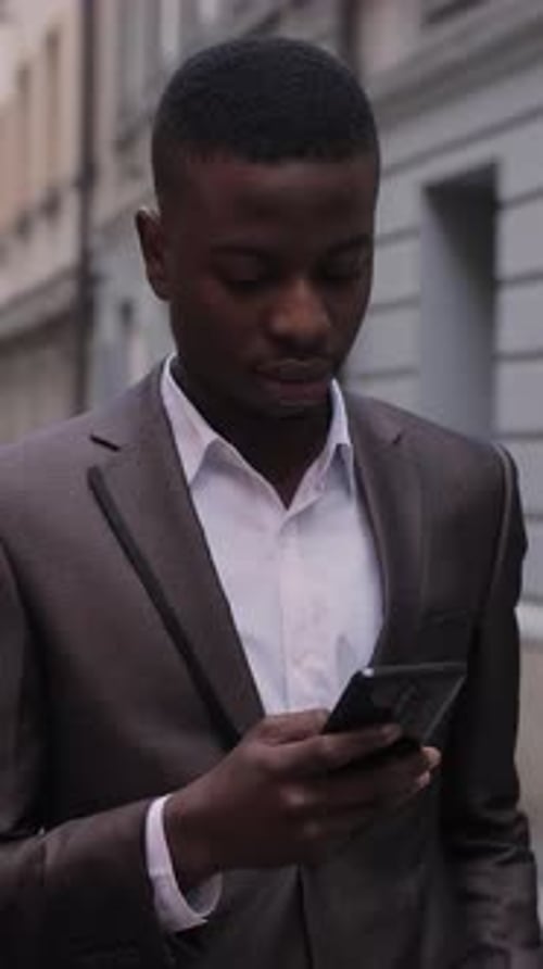 Close Up of African Man Holding Smartphone Outdoors