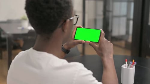 Close up of African Man Holding Phone Horizontal with Green Screen