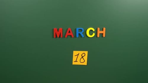 Hand sticking a sticker 18 March calendar day on school board. 18 date of March. Eighteenth day