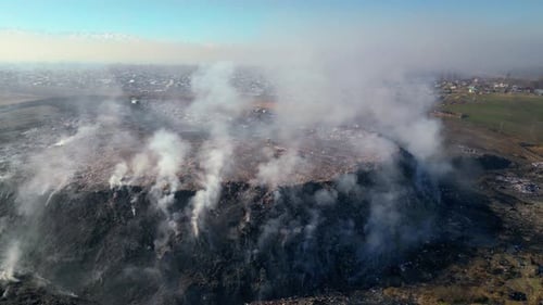 Aerial view of burning trash piles in landfill