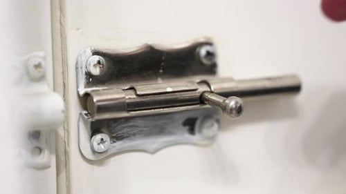 Locking a door with a simple latch on a closer view.