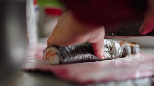 Slicing a delicious sushi roll close up