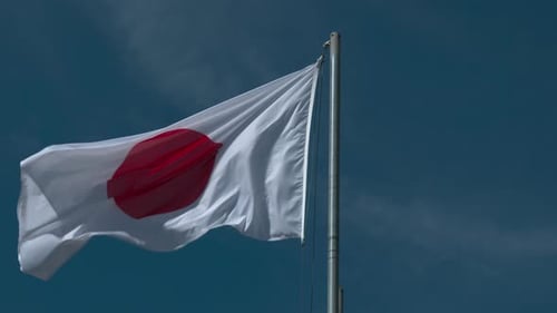 Japanese Flag Waving Against Blue Sky