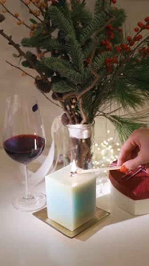 Burning candle close-up. Decorated christmas tree on background. Winter holidays concept. Celebratin