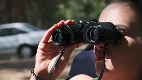 Woman Watching with Binoculars in Forest Landscape