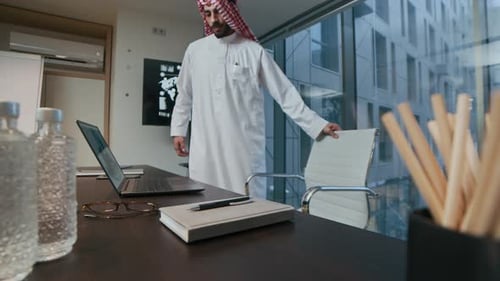 Middle Eastern Businessman Working on Laptop in Modern Office