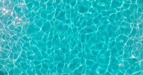 Blue Water in the Swimming Pool with Light Reflections