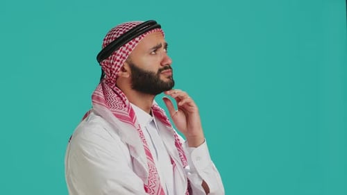 Man Wearing Traditional Headscarf Gesturing in Studio