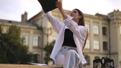 Young Woman Video Calling Outside College Building