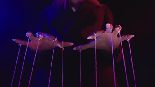Hände, die Saiten in einem dunklen Raum mit lila Licht kontrollieren