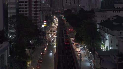Vorwärtsverfolgung des Pendelzuges am Abend in einem Stadtbezirk, stark befahrene, mehrspurige Straße und hohe