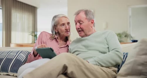 Senior Couple Using Tablet Device at Home