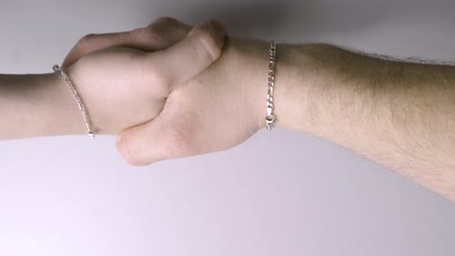 Two Hands Gripping Each Other Tightly In A Handshake. - Close Up Shot