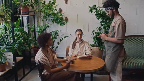 Two Multiethnic Women Ordering Lunch at Cozy Restaurant