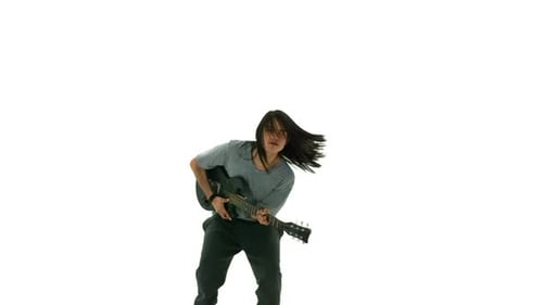 Young man dancing with electric guitar in slow motion studio shot