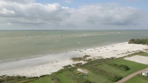 Aerial view of people doing kite surfing along the beach sunny day, Netherlands