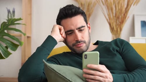 Young Adult Man Using Phone on Couch
