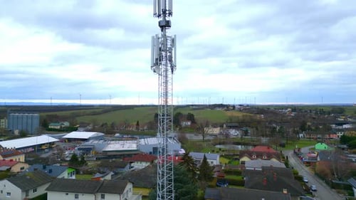 Telecom Tower Overlooking Countryside Houses And Farm Landscape In Daytime. aerial pullback