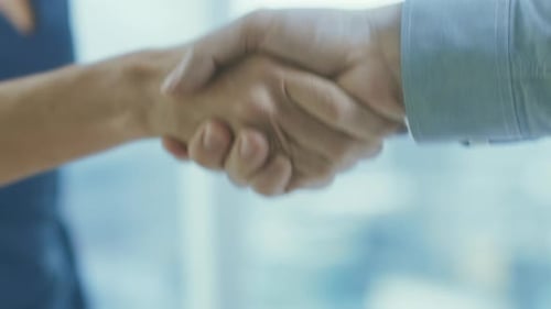 Business Agreement: Man and Woman Shake Hands in Office