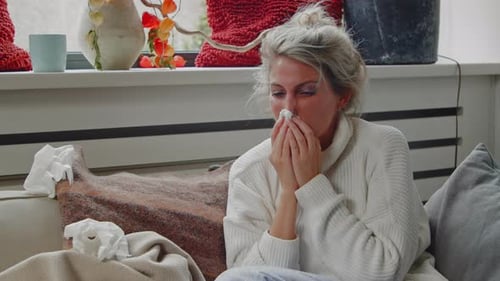 Woman with Cold Resting at Home on Couch