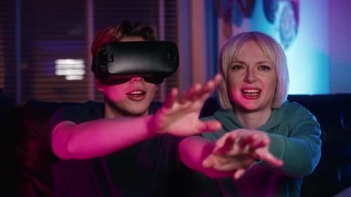 Couple Using Virtual Reality Headset and Laughing