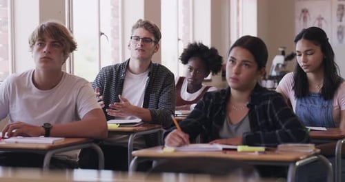 High school student in classroom asking question, learning and studying in his desk with teenage
