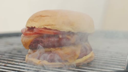 Making American Fat Smash Burger with Fresh Tomatoes and Cheese on Grill Closeup Macro Beef or Pork
