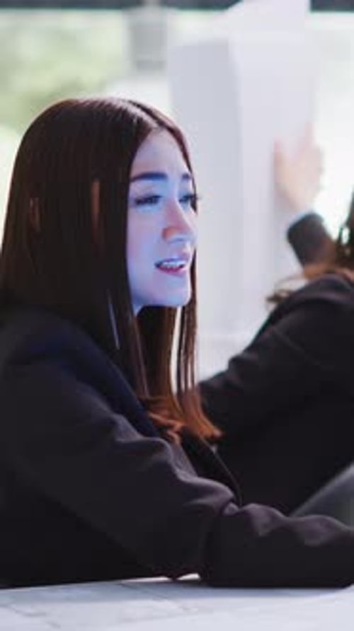 Vertical Video Designer Speaks to Advisor on Projected Hologram in Office Area