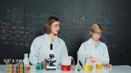 Woman and Boy in Lab Coats Doing Experiment