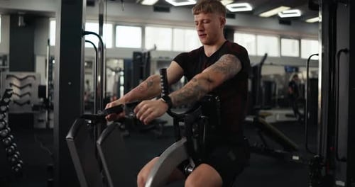 Man Exercises on Seated Row Machine in Gym