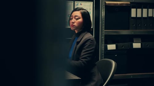 Focused Woman Working at Desk in Dark Office