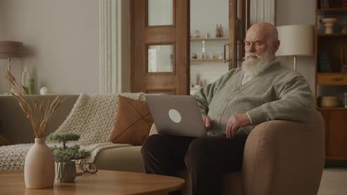 Senior Man Using Laptop in Comfortable Home Setting