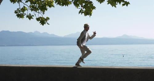 Carefree Male Person in Retro Style Walking at Lake Pier Outdoors