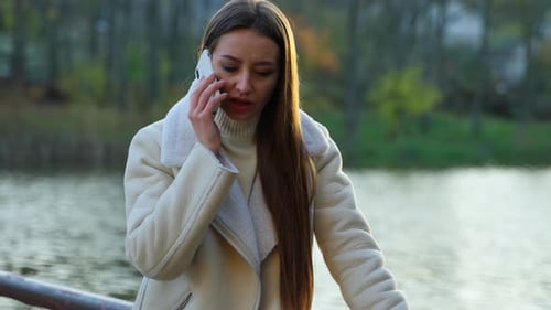 Woman Talking on Smartphone in Urban Park