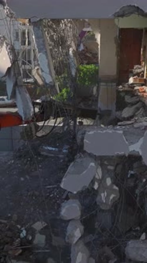 Vertical Video A Powerful Machine with a Hydraulic Breaker Demolishes the Remains of an Old Building