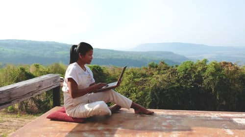 Remote Online Working Digital Nomad Women and Laptop Sitting Outside in Mountains of Thailand