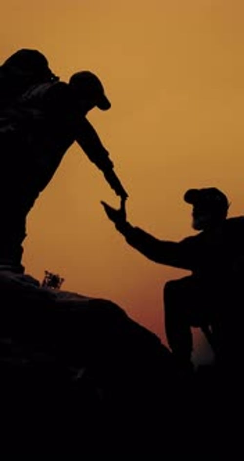 People, silhouette and helping hand for hiking at sunset on mountain, friends