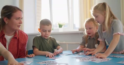 Teacher Guiding Young Children Through Interactive Card Activities at a Bright Classroom Table
