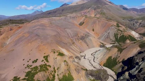 Aerial view of volcanic terrain with river in serene valley, Iceland.