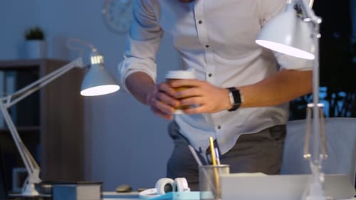 Man works at computer with headphones at night
