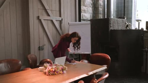 A Professional Woman in a Meeting Space Actively Conducting an Engaging Presentation
