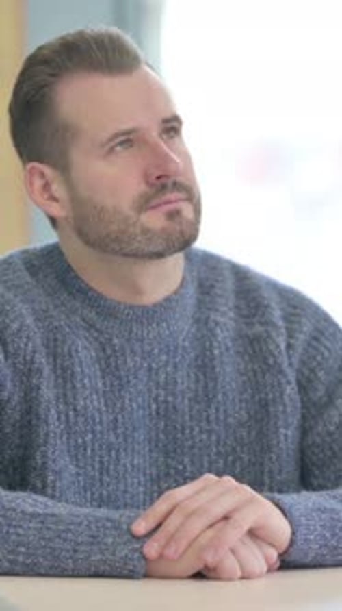 Pensive Middle Aged Man Thinking while Sitting at Work, vertical video