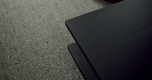 Minimalist Black Table on Textured Gray Carpet in Modern Interior