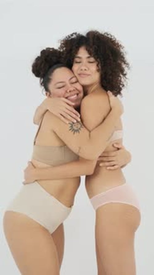 Two Beautiful Women Embracing in Lingerie Studio