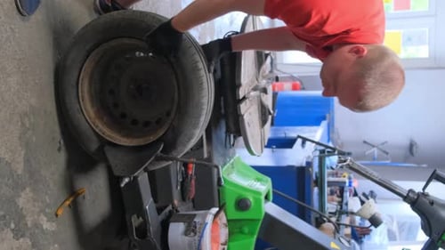 Porträt eines Mechanikers, der Autoräder repariert, Autoservice, Vertikales Video