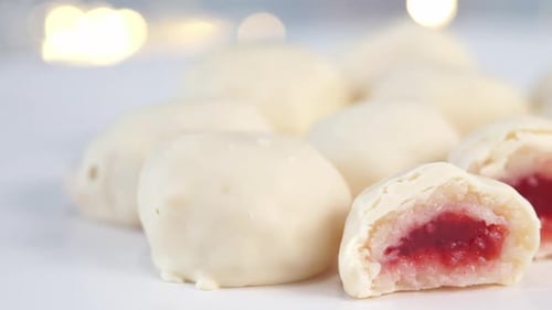 Close Up of White Chocolate Candies with Berry Strawberry Filling Rotates on Tray